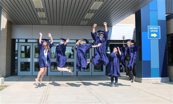 graduates jumping in front of the school graduates jumping in front of the school