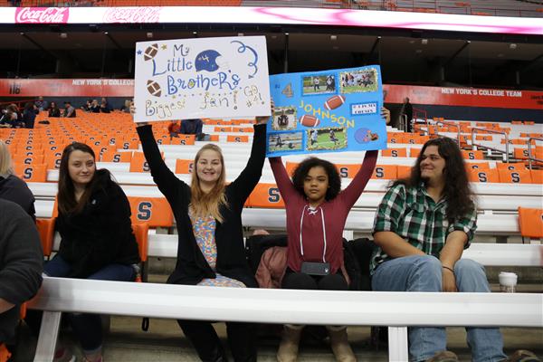 fans at dome game with signs